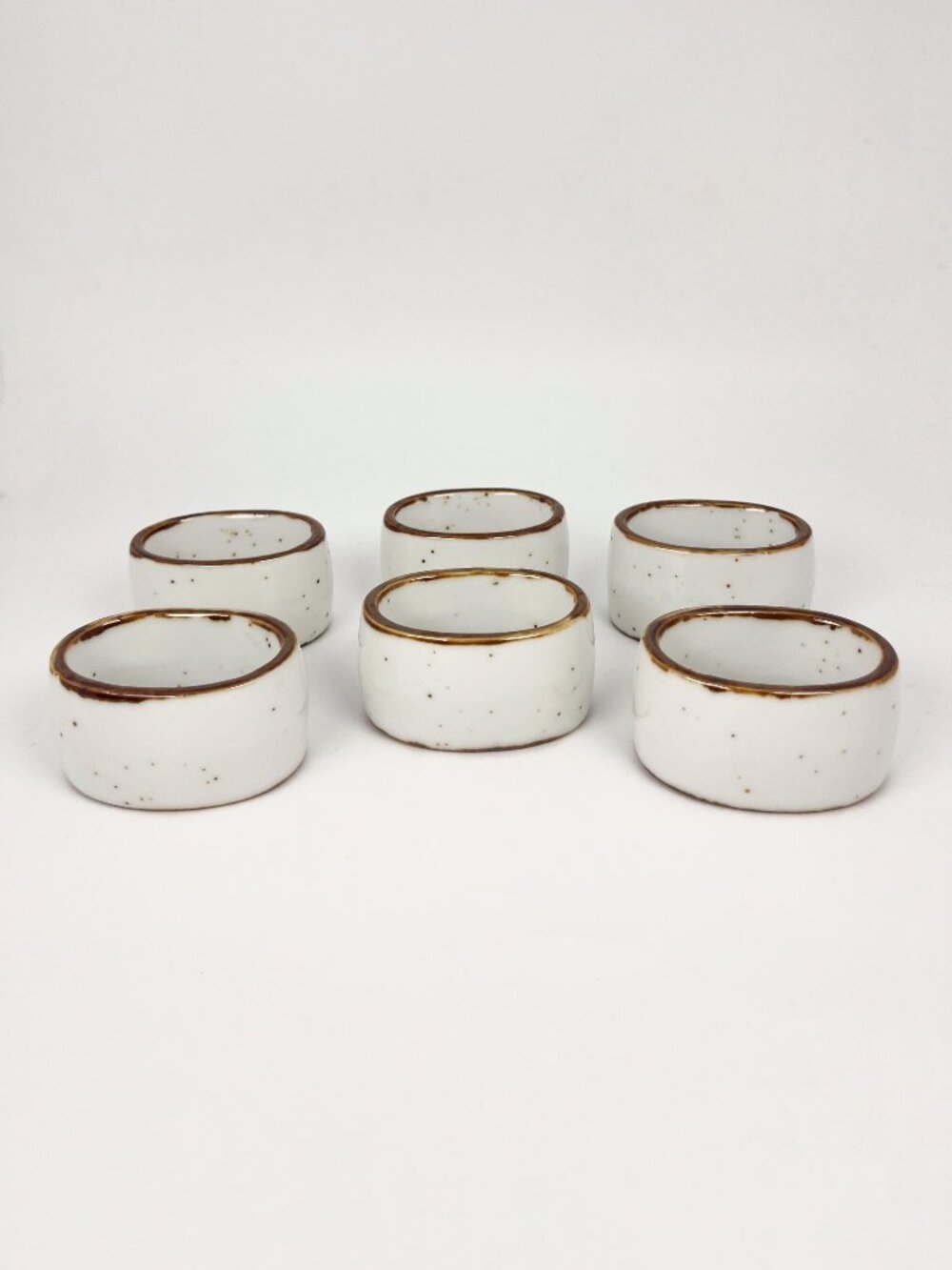 Set of 6 ceramic napkin ring holders in off white with brown edges and speckles